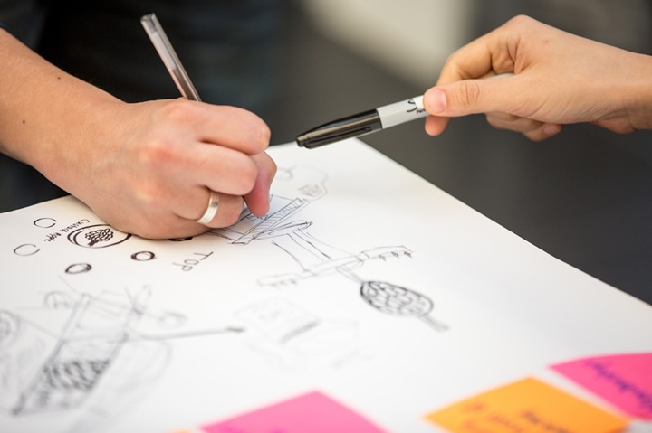 Equipo colaborando en sesión de innovación, representando el trabajo conjunto entre empresas y talento emprendedor.