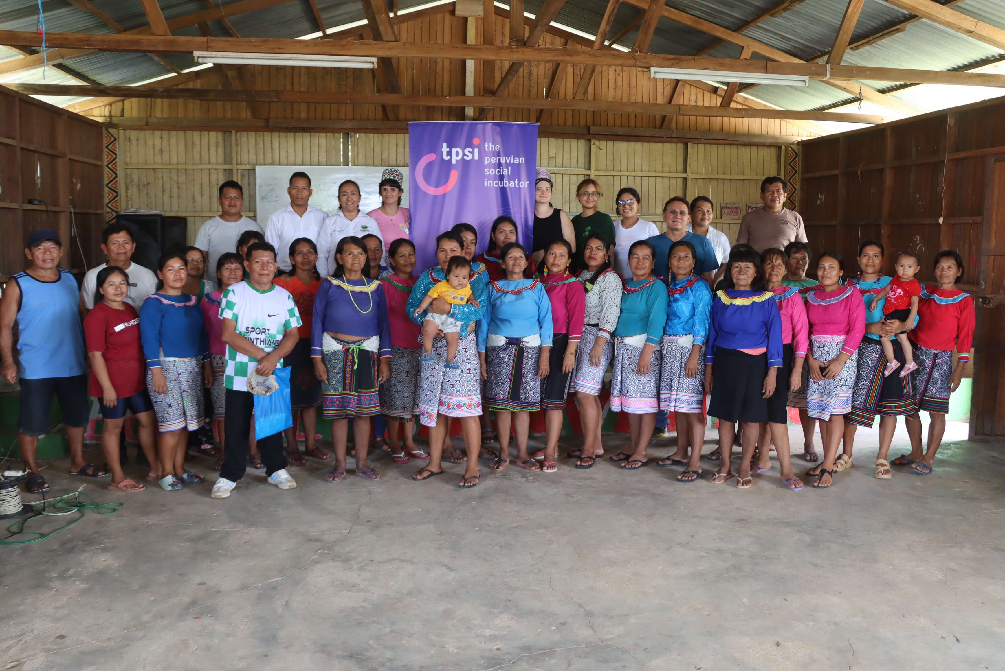 Grupo comunitario posando junto a un banner de TPSI, reflejando participación en el taller e impacto colectivo.